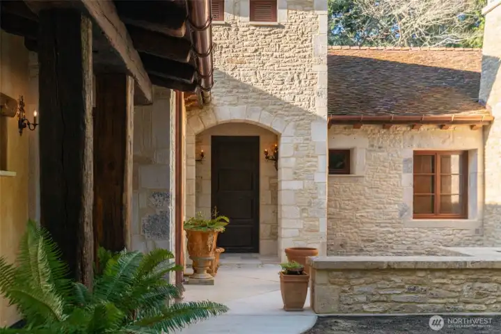 Entry courtyard framed by limestone walls and classic European detailing.