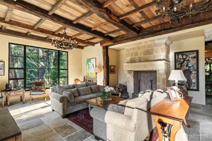 A refined gathering space where historic materials and modern comfort coexist seamlessly. A striking fireplace crafted from reclaimed French limestone anchors the room.