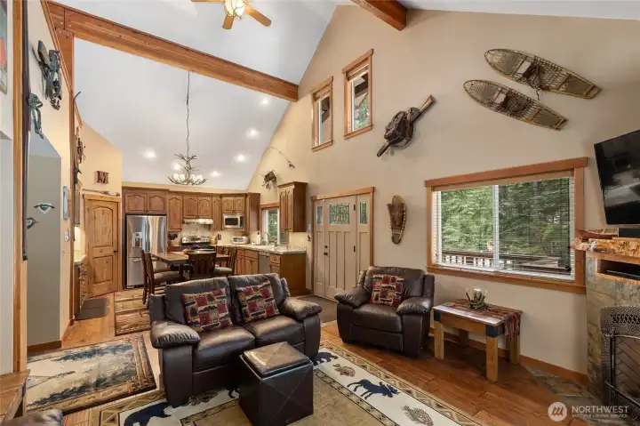 View from the living room to the dining room and kitchen. See the vaulted ceilings and beautiful exposed wooden beams.