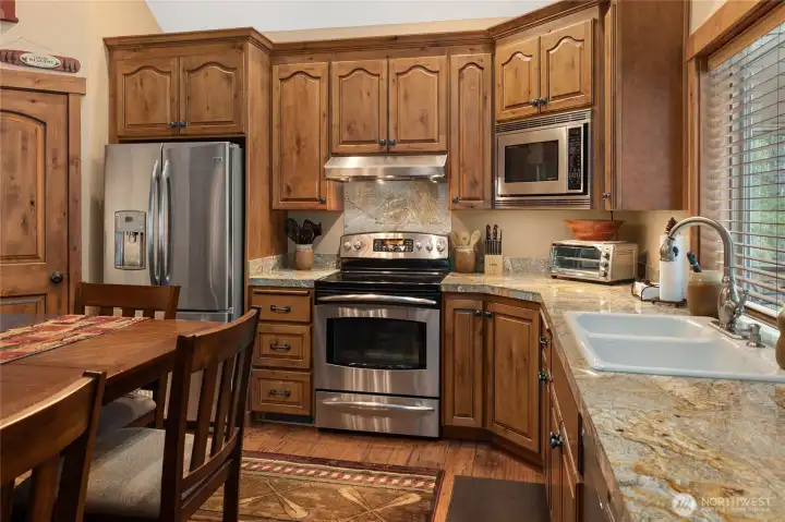 Custom knotty alder cabinets in this kitchen with beautiful granite counter tops. Nice stainless steel appliances through out kitchen.