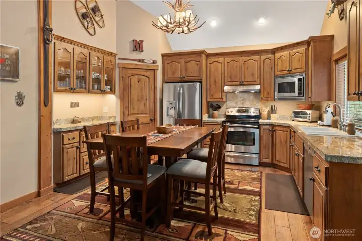 There is a large kitchen pantry is in the corner. Kitchen has plenty of counter space surrounded by these stunning custom cabinets and large kitchen window to allow for plenty of natural light.
