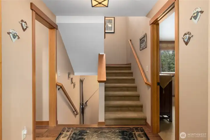 Main floor hallway to show stairs up and stairs down, also see primary bedroom on your right and main floor restroom on your left here.