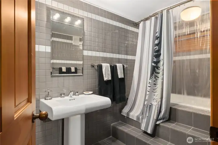 Lower level bathroom with a large tub and custom tile work throughout.