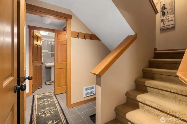 View of the lower floor landing. You can see bathroom to your right (at the bottom of the stairs), also laundry room on this floor an large area that is currently being used or a bedroom.