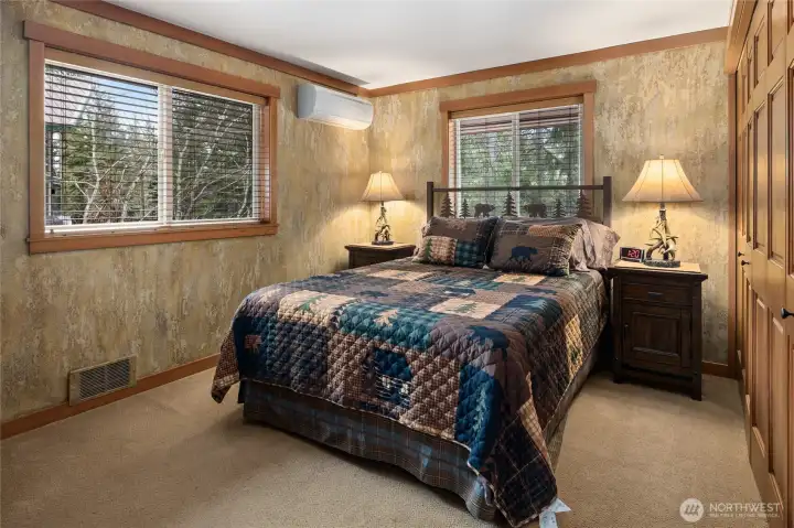 Main floor primary bedroom. Solid wood closet doors and large windows to natural light. Also see a mini split for extra heat or air conditioning.