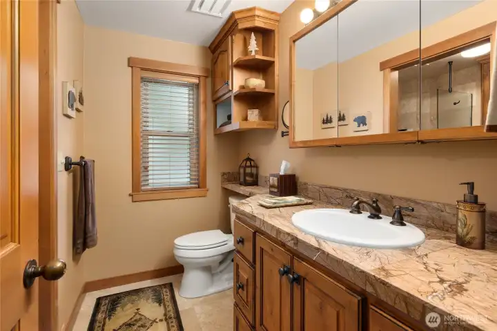 Main floor 3/4 bathroom, nicely done with tile floors, custom cabinets & granite counter tops.