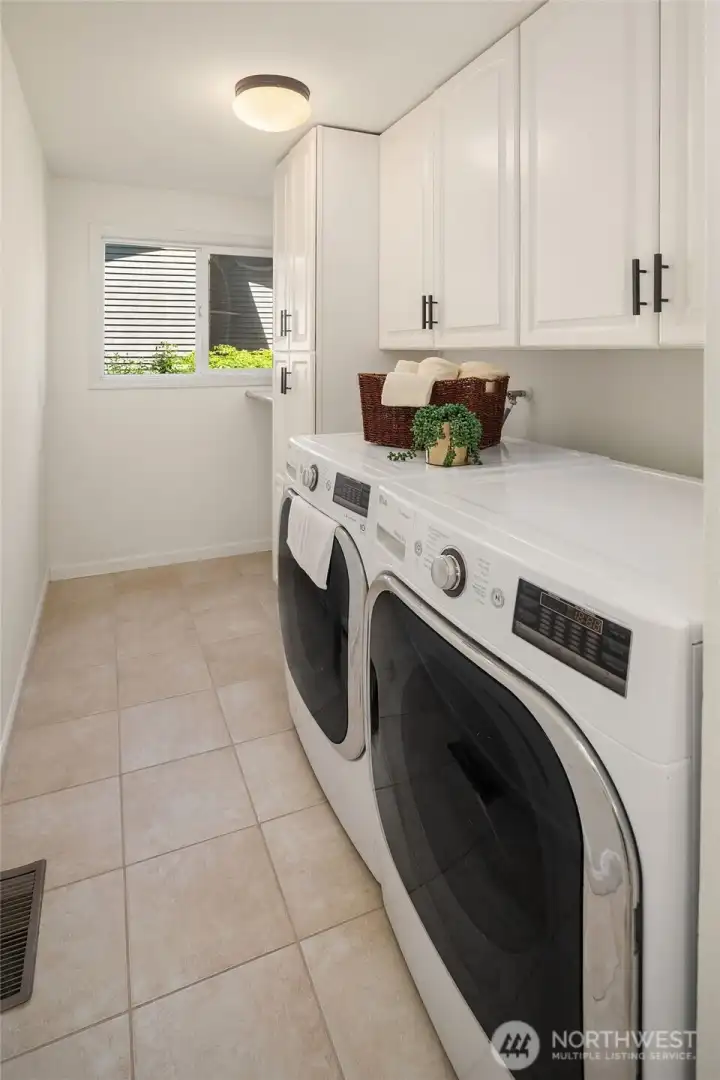 Full laundry room with built-in cabinetry.