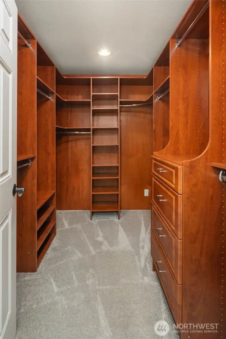 Gorgeous custom organizers in the primary walk-in closet.