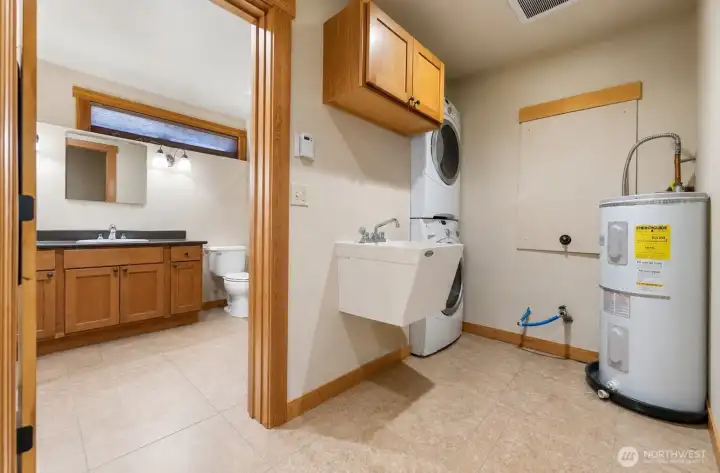 Laundry and utility area next to the downstairs bathroom. Photo cleared of all furniture and belongings using Chat GPT Laundry and utility area next to the downstairs bathroom. Photo cleared of all furniture and belongings using Chat GPT
