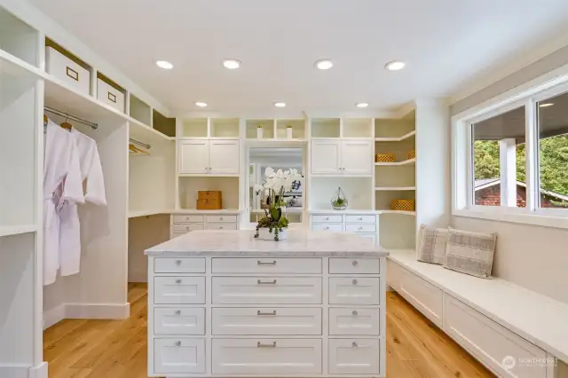 Luxurious walk-in closet complete with vanity, pocket, French doors, and hardwood floors.