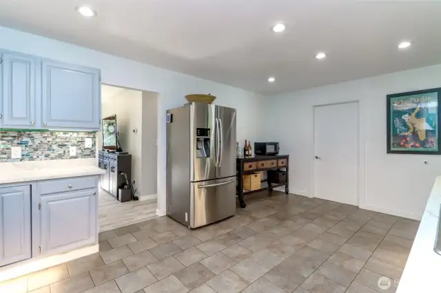 Kitchen eat spacing with movable island for extra prep/storage space.  Door to pantry/furnace room.