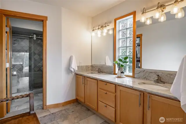 Large ,comfortable Primary bath with double sinks, granite countertops, tiled floors and shower.
