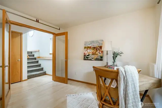 Third bedroom, currently set up as an office with laminate floors and flooded with natural morning sunlight.