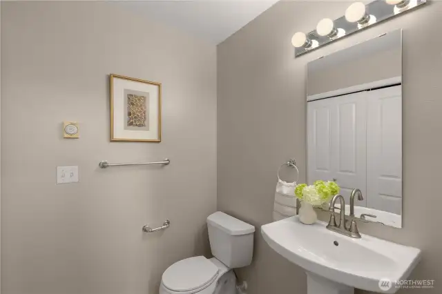 Updated powder room with new sink, faucet, vinyl flooring, and a convenient side-by-side washer/dryer closet