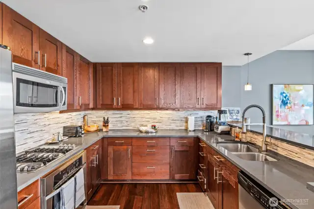 The chef's kitchen has been updated with new countertops and custom tile backsplash. Look at the terrific cabinet space!