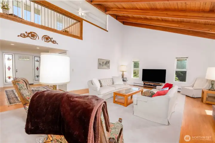 Living room right off the entry, vaulted ceilings give access to upper level balcony for a real open-concept feel