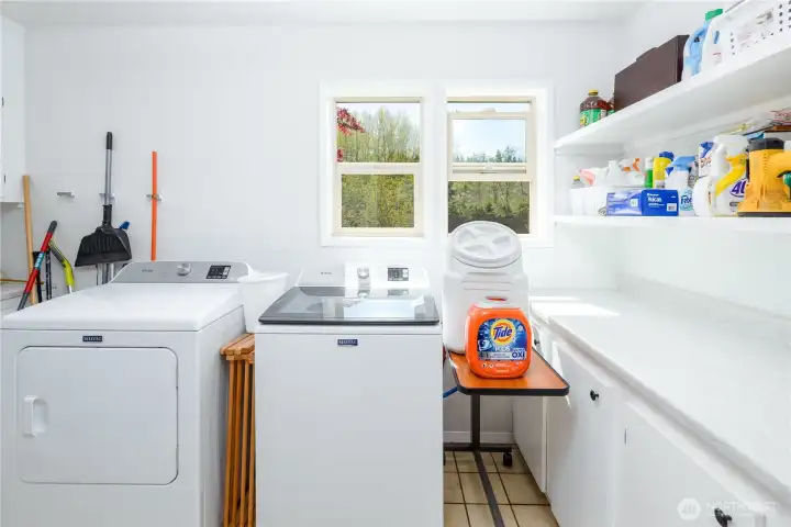 Main floor laundry with ample cabinets and countertop space