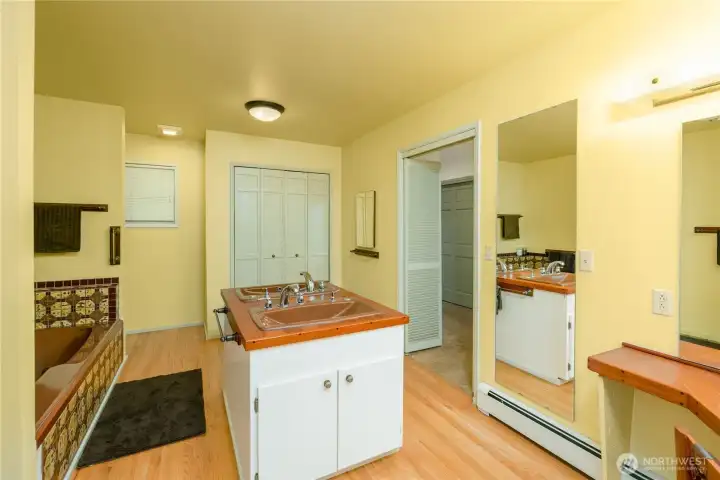 Primary bath with jetted tub, duel sinks shower, linen closet and vanity dressing table