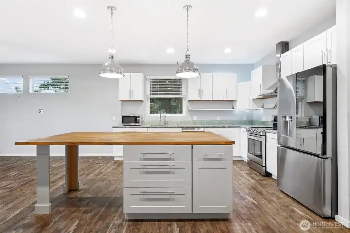 Kitchen features butcher block island and wide walking space