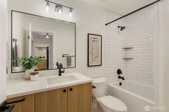 Full bath located on the second floor, tiled shower/bath with a quarts countertop sink.