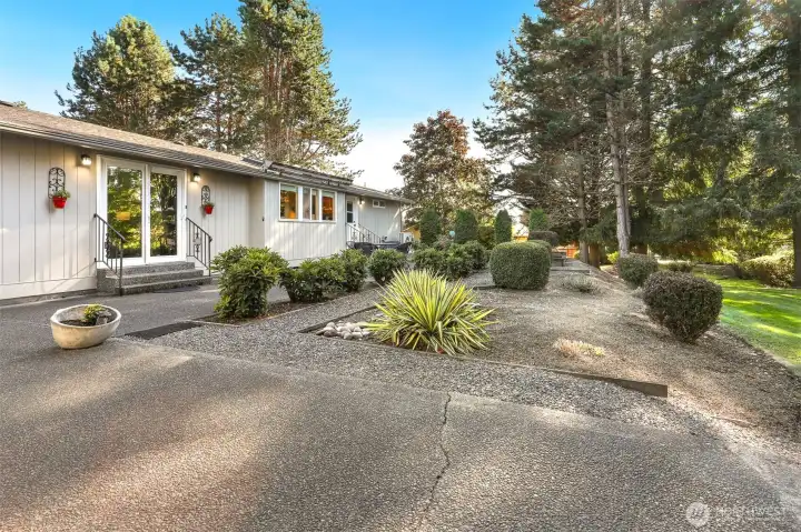 Front of home with a patio and bordering a community greenbelt, trail and creek on both the west and south sides