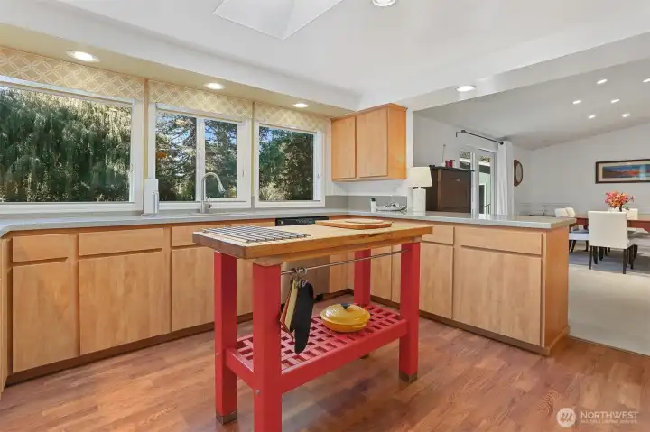 Updated Kitchen features laminate flooring, skylight, center butcher block island, refaced cabinets, corian style countertops, built in over and counter cooktop.  Opens to formal living and dining rooms.  Overlooks the patio, greenbelt, trail and creek