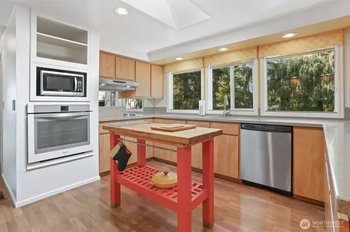 Updated Kitchen features laminate flooring, skylight, center butcher block island, refaced cabinets, corian style countertops, built in over and counter cooktop.  Opens to formal living and dining rooms.  Overlooks the patio, greenbelt, trail and creek