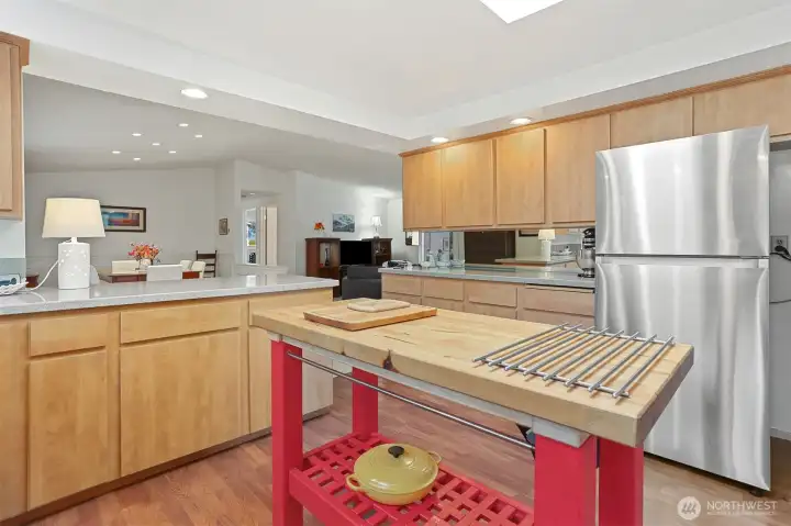 Updated Kitchen features laminate flooring, skylight, center butcher block island, refaced cabinets, corian style countertops, built in over and counter cooktop.  Opens to formal living and dining rooms.  Overlooks the patio, greenbelt, trail and creek