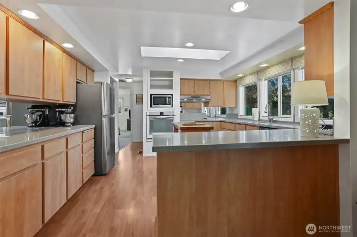 Updated Kitchen features laminate flooring, skylight, center butcher block island, refaced cabinets, corian style countertops, built in over and counter cooktop.  Opens to formal living and dining rooms.  Overlooks the patio, greenbelt, trail and creek