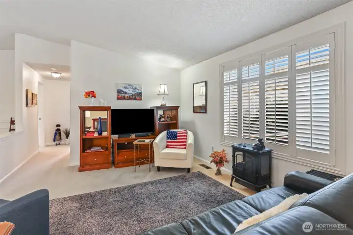 Formal living room with vaulted ceilings opens to the dining room.