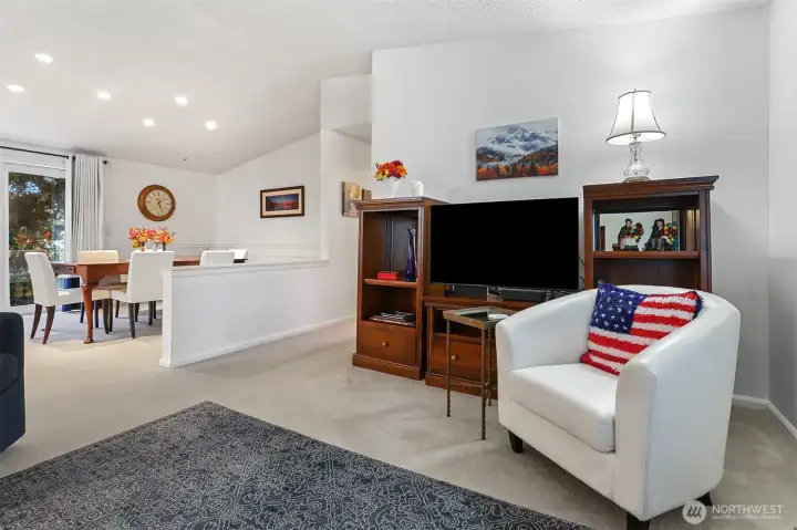 Formal living room with vaulted ceilings opens to the dining room.