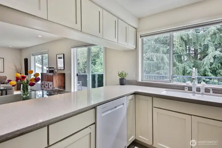 The large window at the kitchen sink looks out upon the generously sized deck. Notice the cabinets above the counter, providing great kitchen storage space.