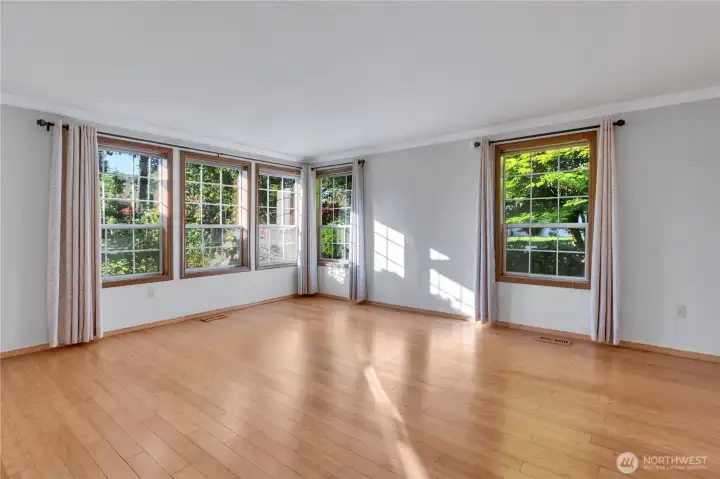 Large living room boasting wood wrapped windows and lovely white painted crown molding.