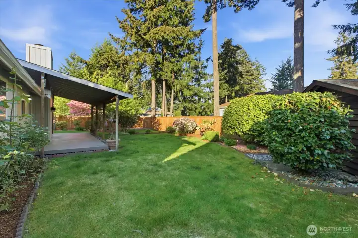 Manicured yard with tons of mature plantings and rhodedendrons, and there's a full sprinkler system too!