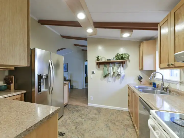The kitchen has good function and opens to dining space on one side and the laundry room on the other.