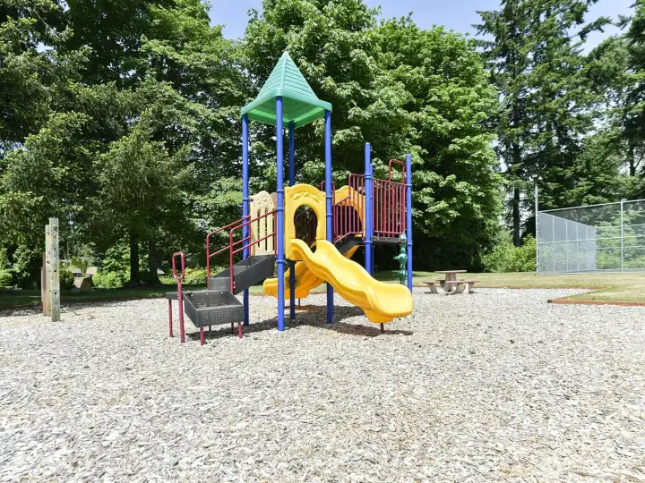 The park has playground equipment and picnic tables along with grassy play areas.