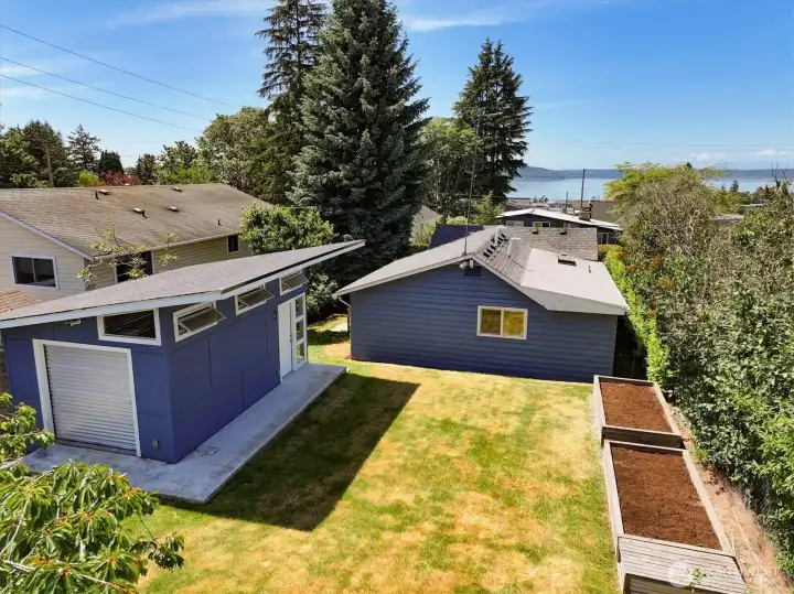 Drone View of Expansive Backyard and Rear of House with Puget Sound in the Distance