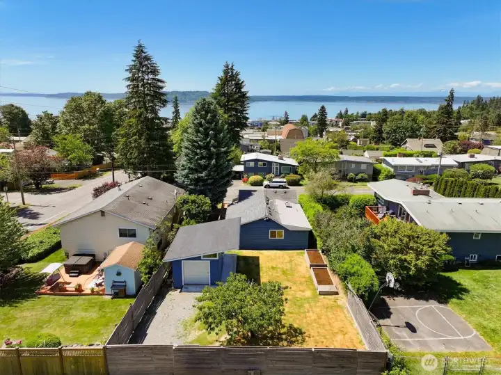 Elevated Drone View of Rear of House, Surrounding Properties, and Puget Sound on the Horizon