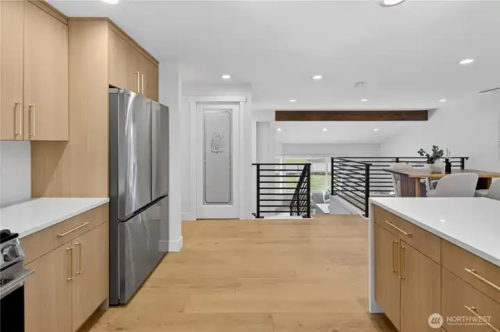 Brass-tone modern cabinet handles add a beautiful finishing touch, with clean lines that echo the custom linear railings for a cohesive designer look. The walk-in pantry, framed by a beautiful etched glass door, elevates the kitchen with both style and function, offering generous space for stored goods, small appliances, and all the baking essentials you like to keep close at hand. Brass-tone modern cabinet handles add a beautiful finishing touch, with clean lines that echo the custom linear railings for a cohesive designer look. The walk-in pantry, framed by a beautiful etched glass door, elevates the kitchen with both style and function, offering generous space for stored goods, small appliances, and all the baking essentials you like to keep close at hand.