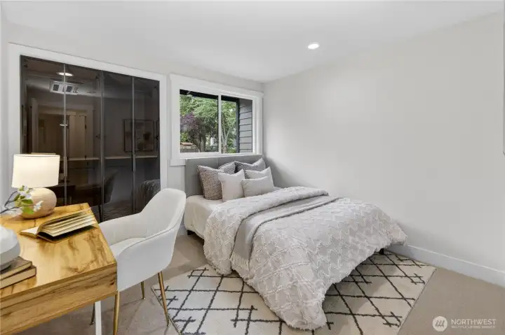 The first bedroom on the right side of the hallway feels soft and restful with new carpet underfoot, a gently slanted ceiling, and a new flush-mount ceiling light paired with recessed lighting for a warm, even glow. Modern smoked-glass closet doors with slim black framing add a stylish designer touch, opening to a generous closet for excellent storage. The first bedroom on the right side of the hallway feels soft and restful with new carpet underfoot, a gently slanted ceiling, and a new flush-mount ceiling light paired with recessed lighting for a warm, even glow. Modern smoked-glass closet doors with slim black framing add a stylish designer touch, opening to a generous closet for excellent storage.