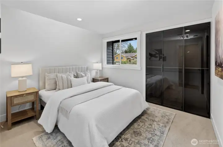Mirroring the bedroom next door, the next bedroom on the right has a clean, tailored feel with new carpet, a gently angled ceiling, and updated lighting that gives the room smooth, balanced brightness. A large closet with smoked-glass doors and slender black frames adds storage with style, bringing a crisp modern edge to the room. Both bedrooms have a northerly view to the front yard, letting the daylight in without the morning sun to wake you on the weekends. Mirroring the bedroom next door, the next bedroom on the right has a clean, tailored feel with new carpet, a gently angled ceiling, and updated lighting that gives the room smooth, balanced brightness. A large closet with smoked-glass doors and slender black frames adds storage with style, bringing a crisp modern edge to the room. Both bedrooms have a northerly view to the front yard, letting the daylight in without the morning sun to wake you on the weekends.