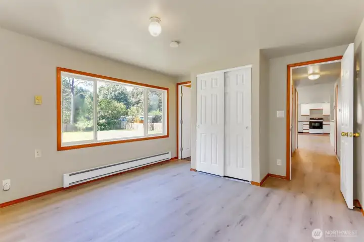 Another view of the primary suite. Ensuite bath on the left and hallway to the kitchen on the right.