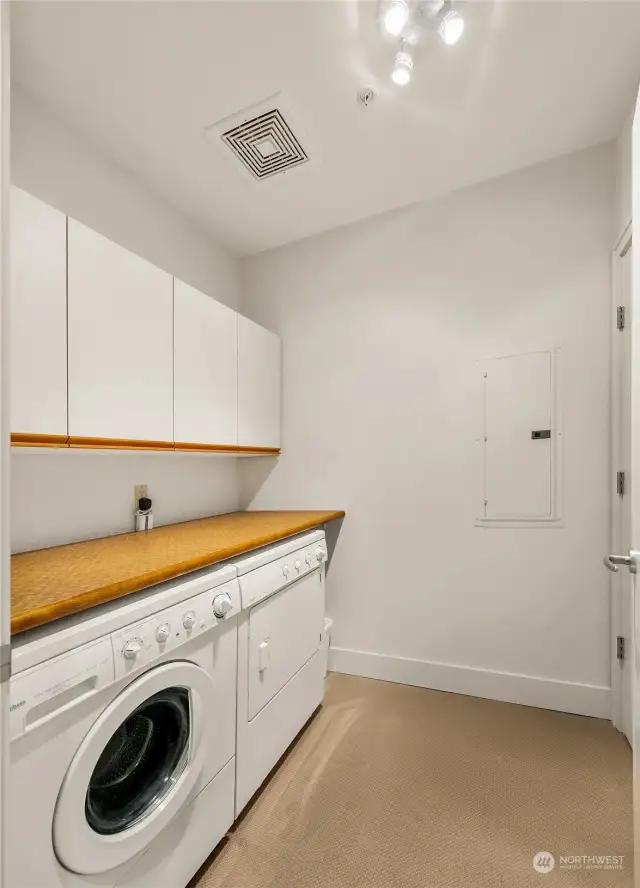 Laundry room has a generous folding table, dryer is gas and plenty of storage behind the door and in the cabinets