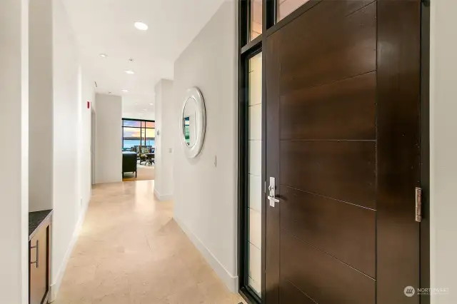 Interior entry and front door to unit #404.  Gorgeous wood door and stone floors and wide hallways.