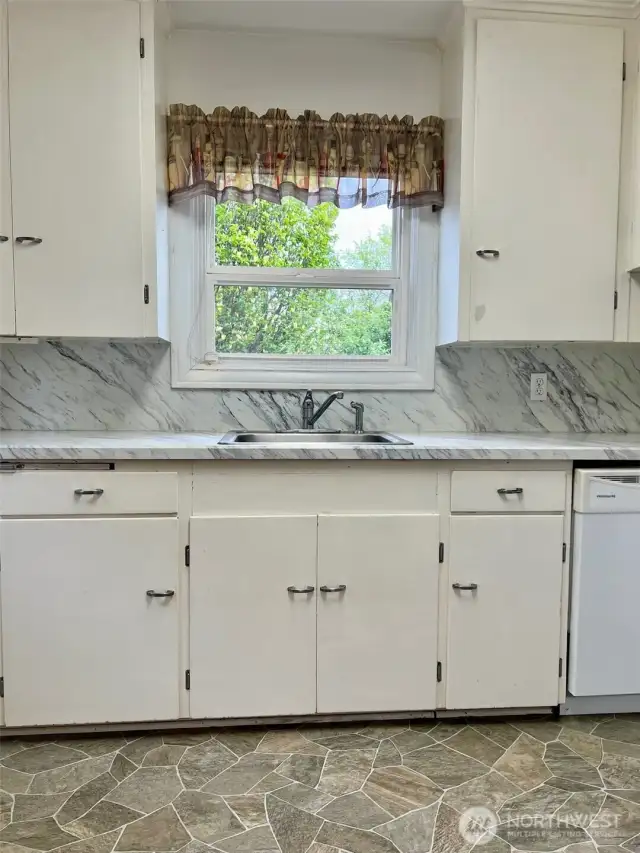 Direct look at the cabinetry, counter & window from the doorway of the of the door to the down stairs garage/shop area