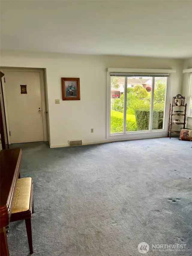 View of the entry, living room and the wall of windows it offers, lots of natural light