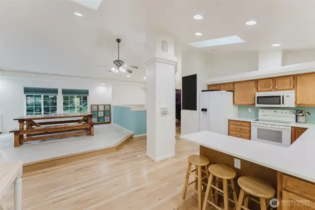 Ceiling fan and then leads open floor plan-style into the kitchen.