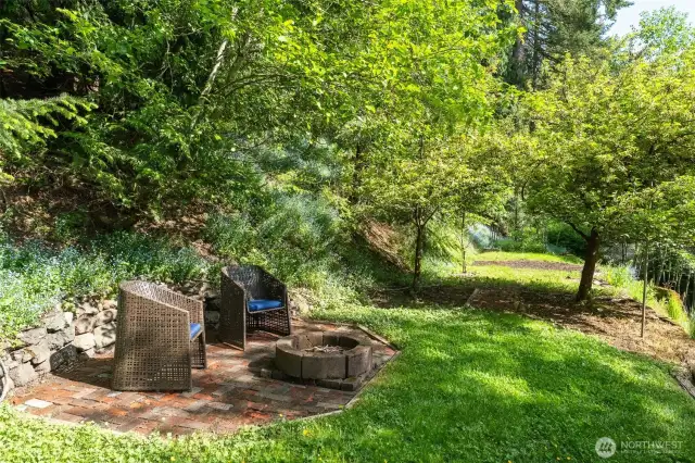 Firepit with seating on the second terrace, fruit trees and in the past had had a trampoline here in the background area.  A lot of morning and midday sun.