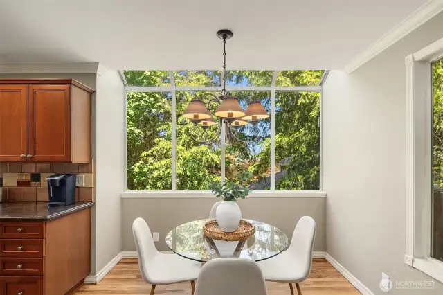 Informal dining space overlooks the mature landscaping of the yard.