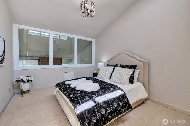 Primary bedroom with vaulted ceiling and new windows overlooking living room